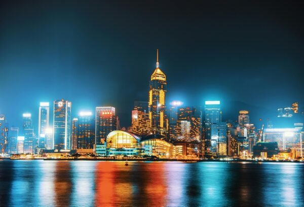 Vivid Hong Kong skyline at night featuring illuminated skyscrapers and waterfront reflections.